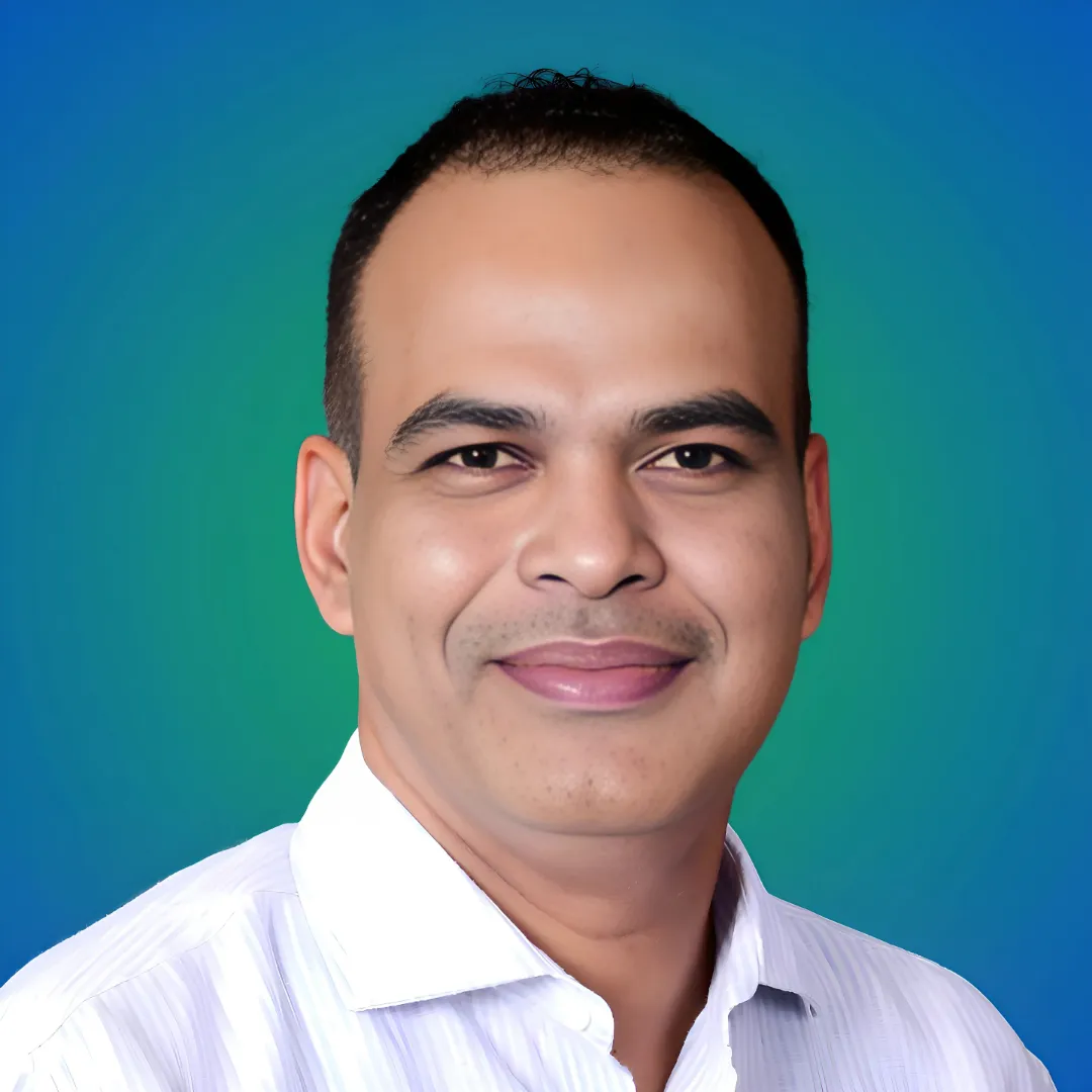Headshot of Dr. Anil Rai, an Ayurvedic Inner Health Professional, smiling and wearing a white collared shirt against a blue and green gradient background. Client of OnlineShree.